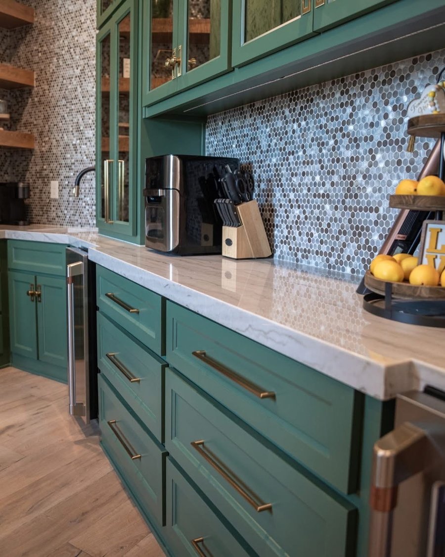 Quartzite countertops in a green kitchen by Gaumats International