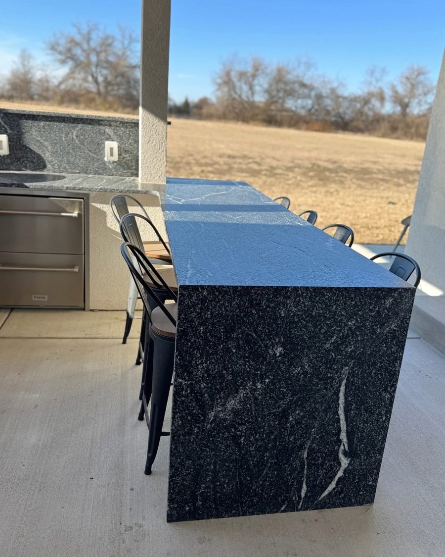 Black granite outdoor bar with waterfall edge by Gaumats International